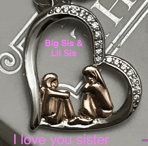 a heart shaped pendant with the words big sis and lil sis on it