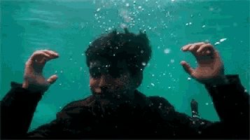 a man is swimming underwater with bubbles coming out of his head