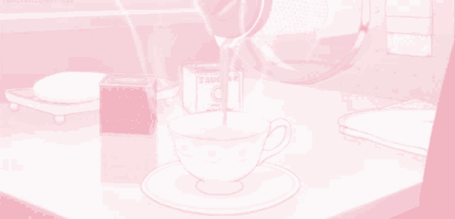 a cup of tea is being poured into a saucer with a box of tea in the background