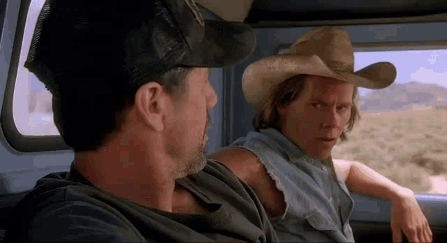 two men in cowboy hats are sitting in a car