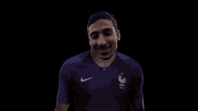 a man in a purple nike jersey is smiling and dancing .