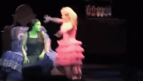 a woman in a pink dress is standing next to another woman in a blue dress