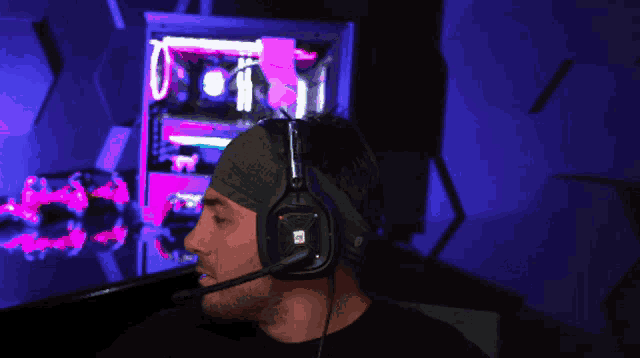 a man wearing headphones is making a funny face in front of a computer