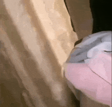 a person is standing in front of a curtain in a room with a pink helmet on .