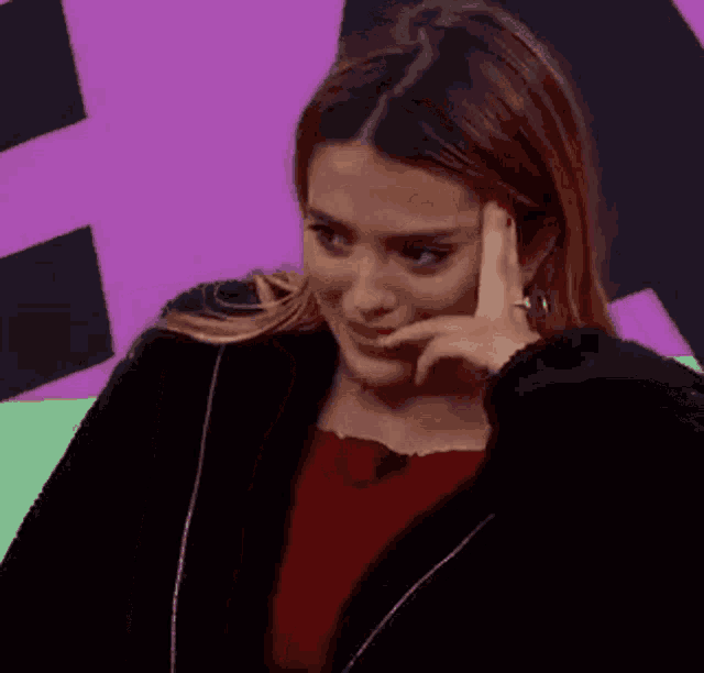 a woman is crying and covering her mouth with her hand .