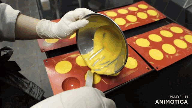 a person is pouring a yellow liquid into a silicone mold and the words made in animotica are visible in the corner