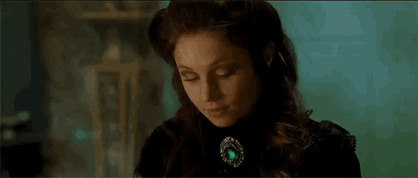 a woman is drinking a cup of tea in a room .
