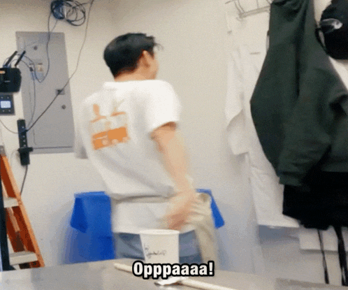 a man in a white shirt is standing in front of a cup that says oppaaa on it