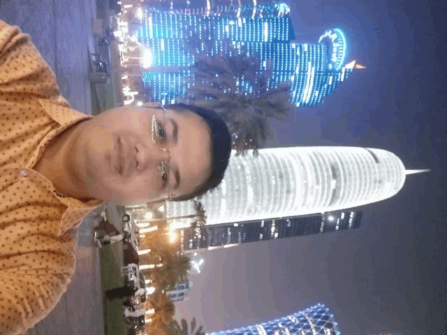 a man taking a selfie in front of a skyscraper that says allianz
