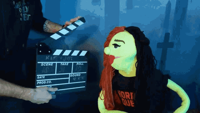 a puppet wearing a shirt that says hori que is being filmed