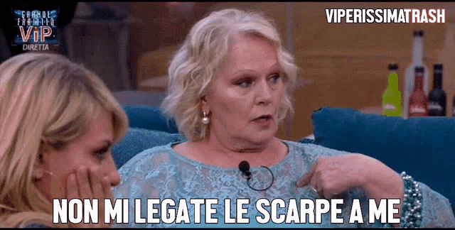 two women are sitting on a couch and one of them says " non mi legato le scarpe a me "