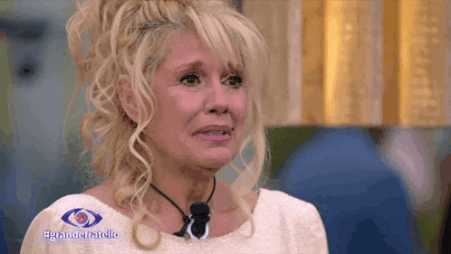 a woman in a white dress with the words grandefratello on the bottom