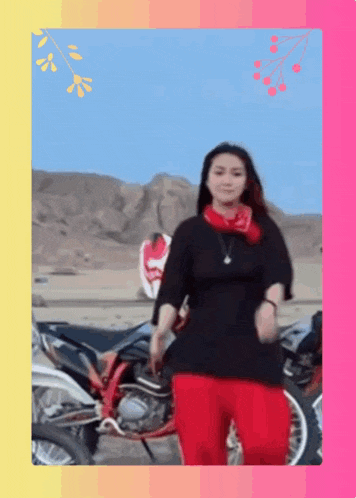 a woman in red pants is standing in front of a motorcycle