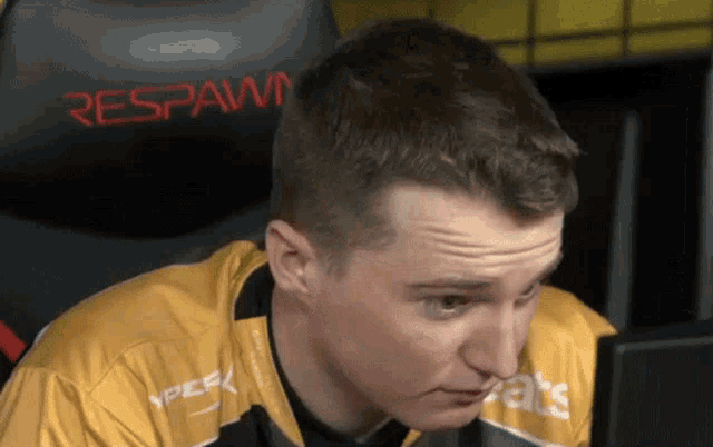 a man sits in front of a chair that says respawn on it