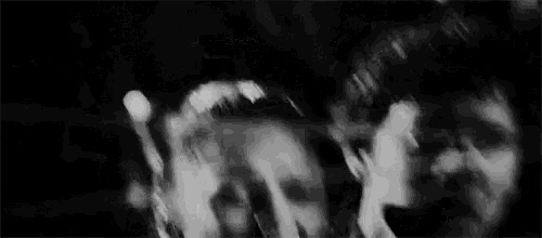 a man and a woman are standing next to each other in a dark room .