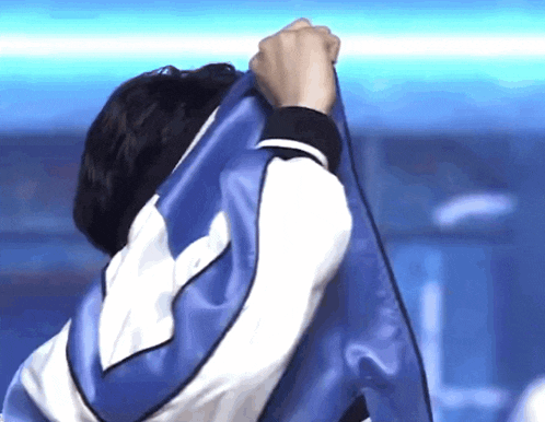 a man is holding a blue and white cloth over his head .