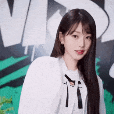 a young woman with long hair is wearing a white shirt with the letter t on it .