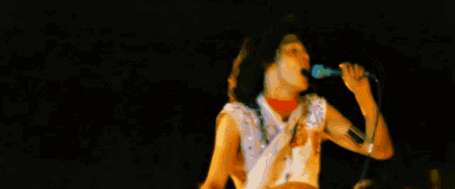 a woman is singing into a microphone while another woman looks on