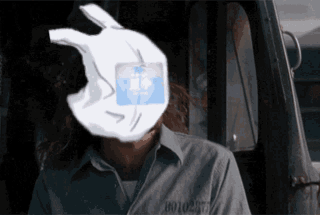 a man in a prison uniform has a sticker on his head that says 8010-977