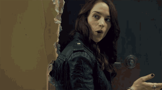 a woman in a leather jacket is giving the middle finger and the word silence is behind her