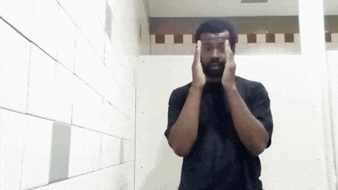 a man in a black shirt is standing in a bathroom