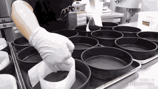 a person wearing white gloves is working in a kitchen with a sign that says " made in animatica "