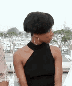 a woman in a black top and hoop earrings is sitting next to a man .