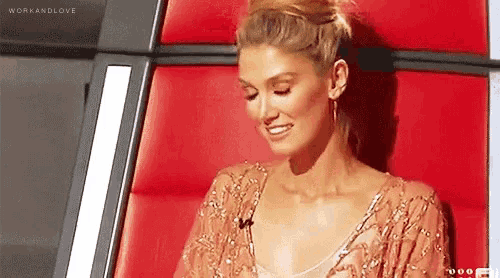 a woman in a dress is sitting in a red chair .