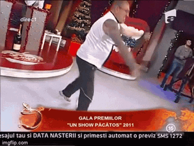 a man is dancing in front of a sign that says gala premiilor on it