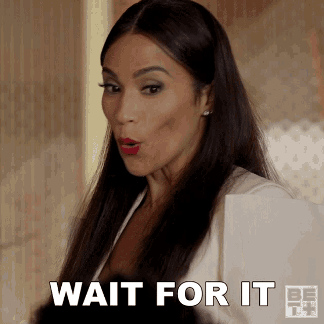a woman with a surprised look on her face and the words wait for it below her