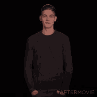 a young man in a sweater is standing with his hands in his pockets and the hashtag #aftermovie