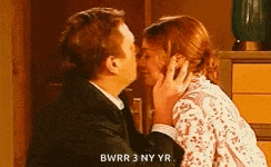a man and a woman are kissing in a room and the man is saying `` bwrr 3 ny yr '' .