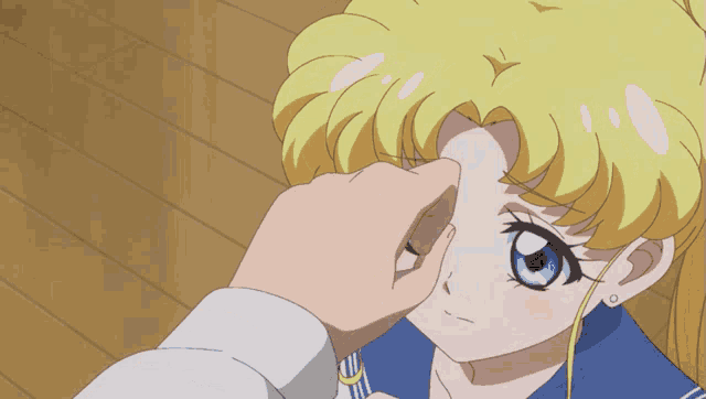 a person touching a girl 's eye with the word ouch visible