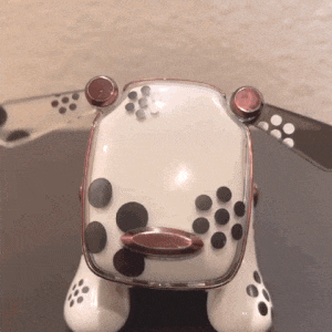 a white toy dog with black spots on its paws