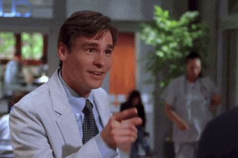 a man in a white coat and tie is pointing at something