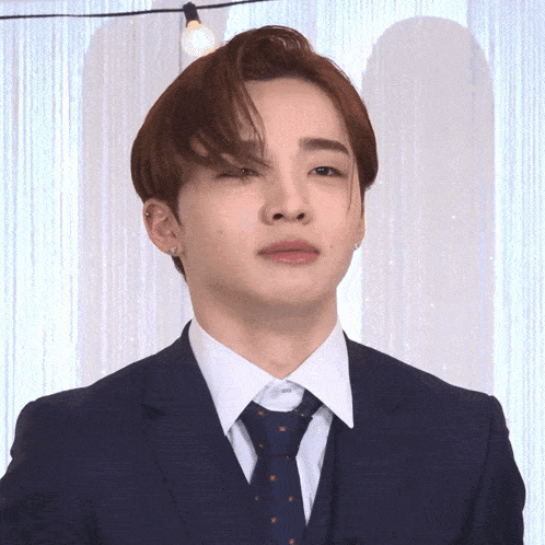 a man in a suit and tie is making a face