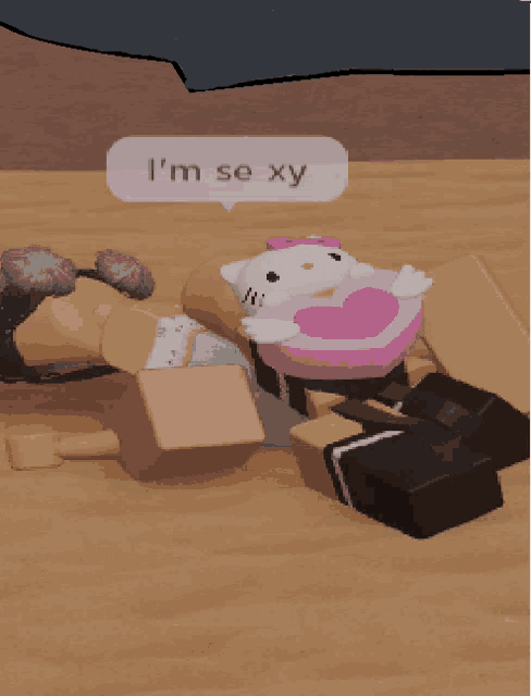 a hello kitty stuffed animal is laying on a wooden floor with a speech bubble that says i 'm se xy