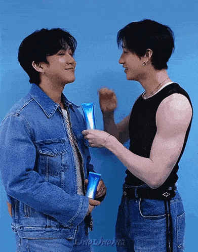 two men are standing next to each other and one is holding a bottle of lotion