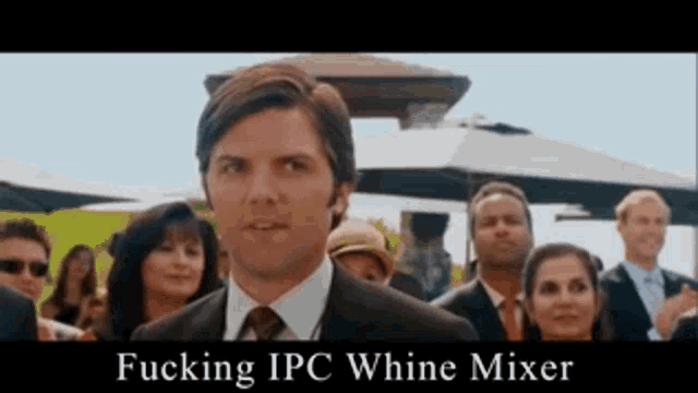 a man in a suit and tie stands in front of a crowd of people with the words fucking ipc whine mixer above him