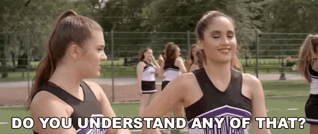 two cheerleaders are standing next to each other on a field and one of them is asking the other if she understands any of that