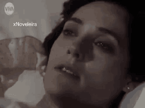 a woman is laying in a hospital bed with her eyes closed .