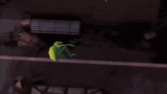 an aerial view of a city street at night with a green frog on a building