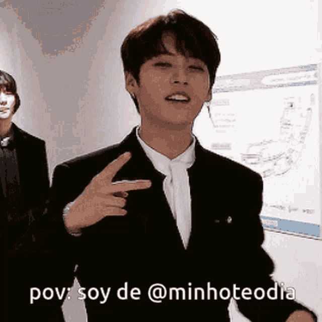 a man in a suit and tie is pointing his finger at the camera with the caption pov soy de @minhteodia