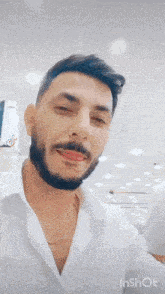 two men with beards are standing next to each other and smiling for a picture .