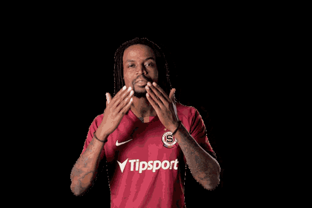 a man with dreadlocks is wearing a shirt that says tipsport on it