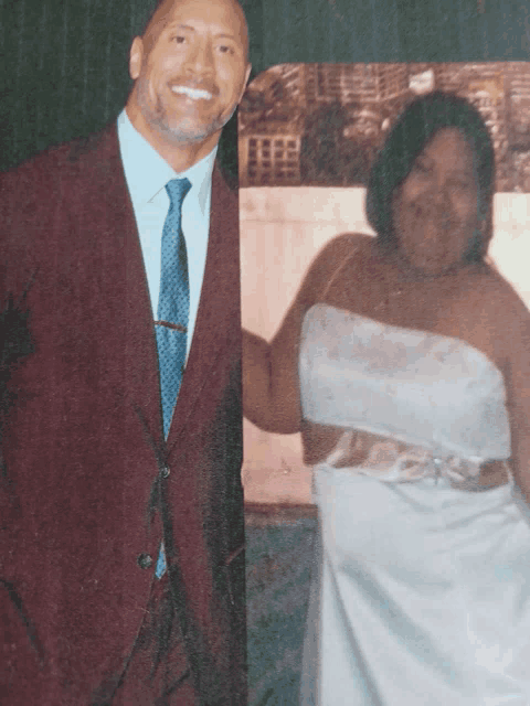 a man in a suit and tie stands next to a woman in a wedding dress