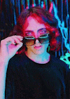 a young man with red hair is wearing sunglasses .