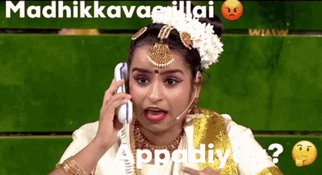 a woman in a sari is talking on a cell phone and making a funny face .