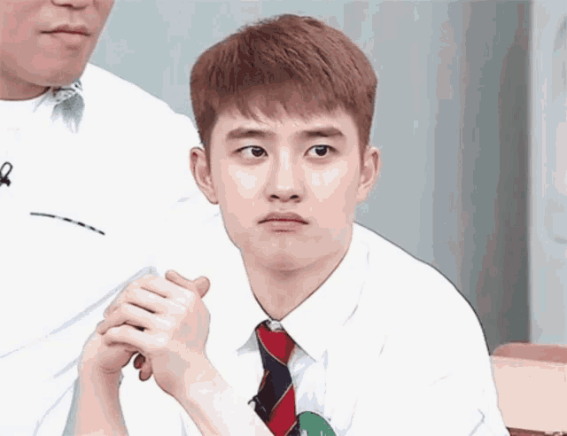 a young man in a white shirt and tie is making a face