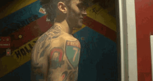 a man with a mohawk has a tattoo of the number 7